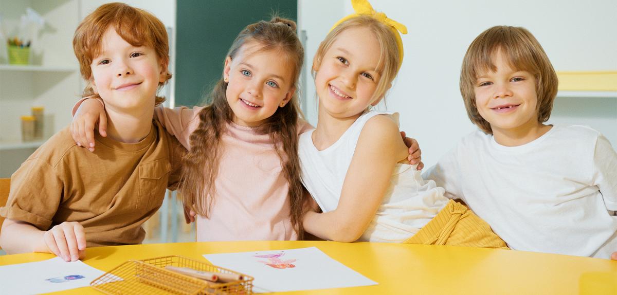 Four smiling children in an elementary classroom