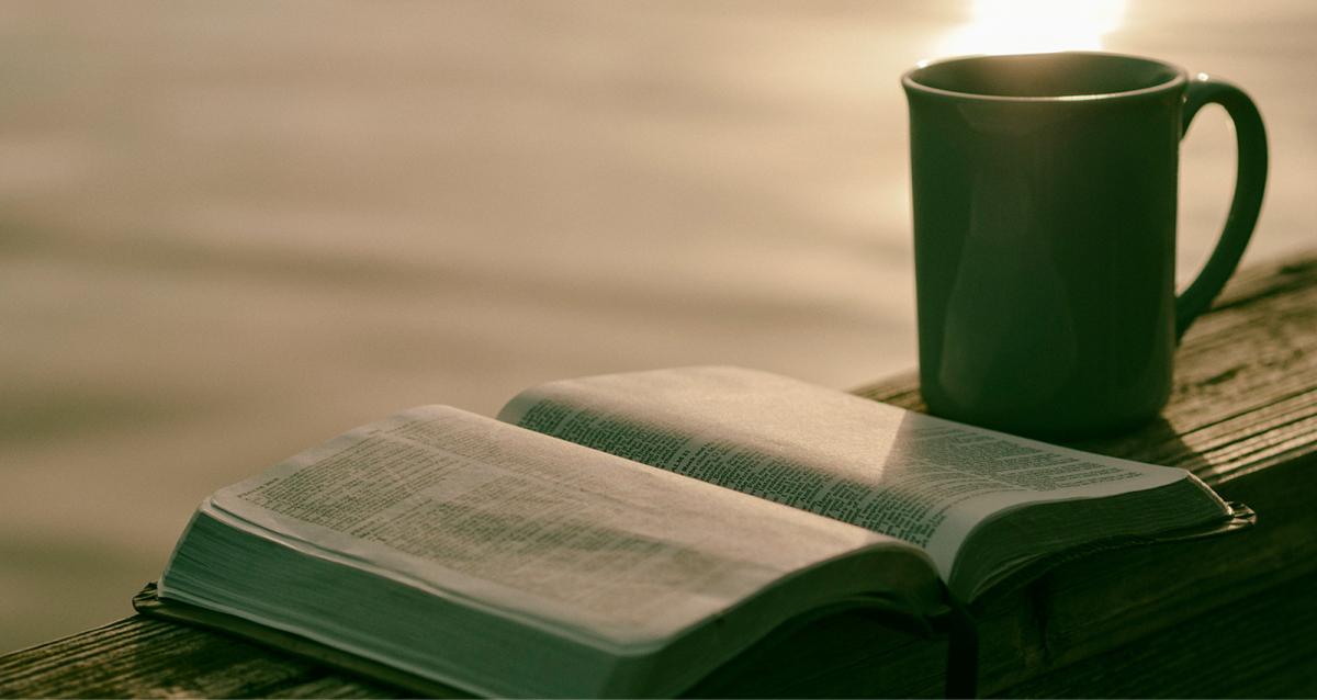 An open Bible and a steaminc cup of coffee