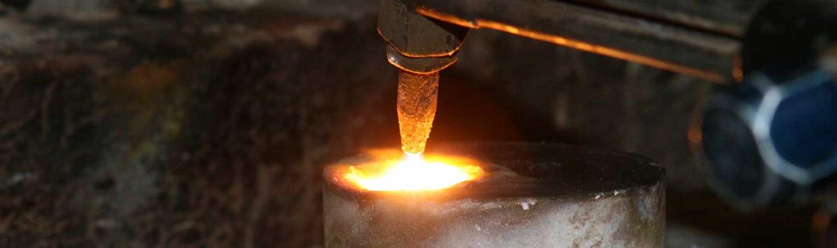 Welder soldering a pipe on the ground.